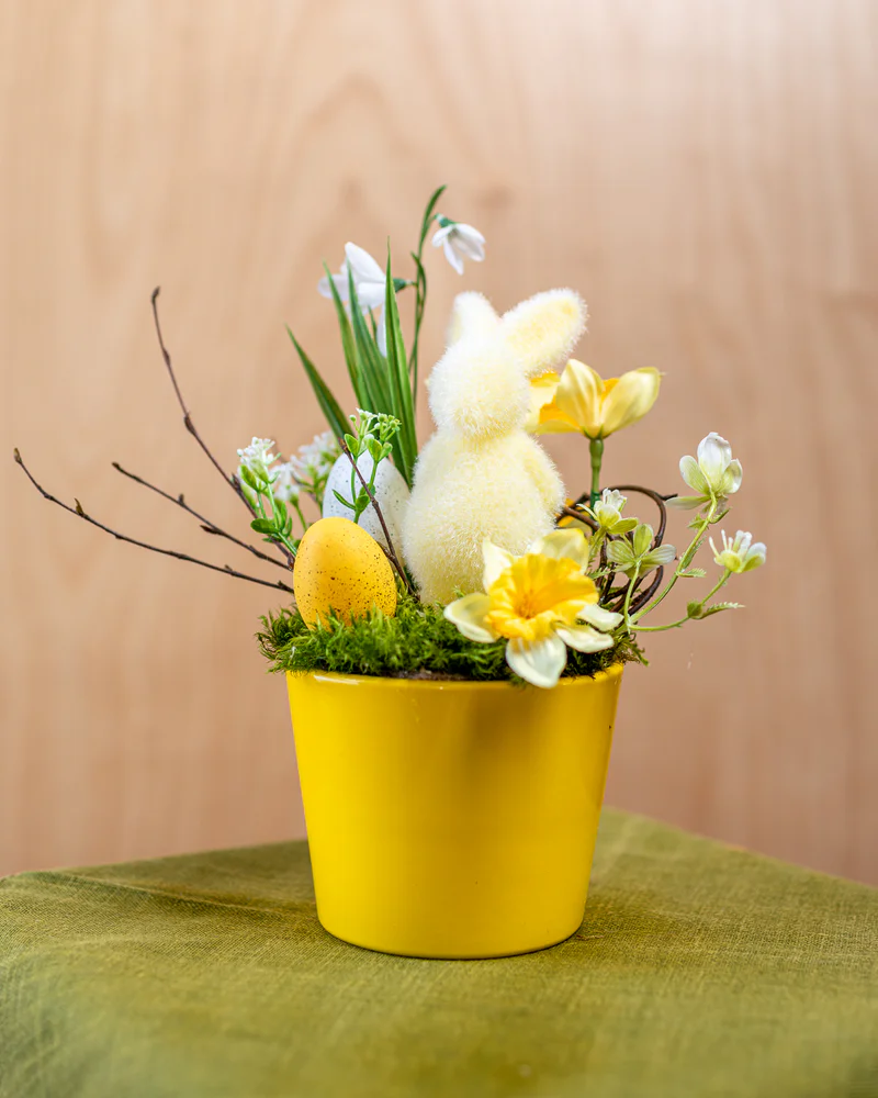 Gaiši dzeltenīgs floristikas kārtojums ar zaķi un dabīgiem pūpoliem podiņā priekš Lieldienām